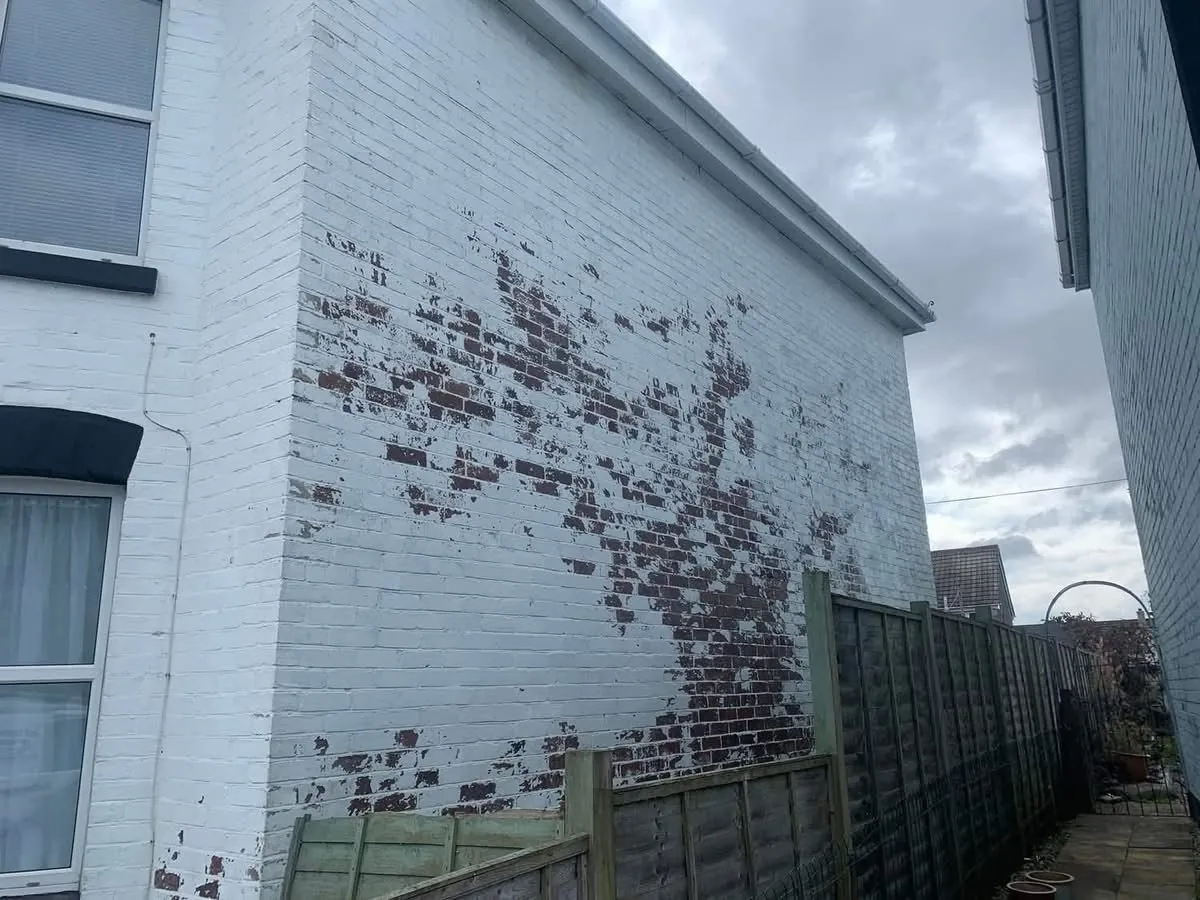 Peeling paint on a brick wall before redecoration in Plymouth
