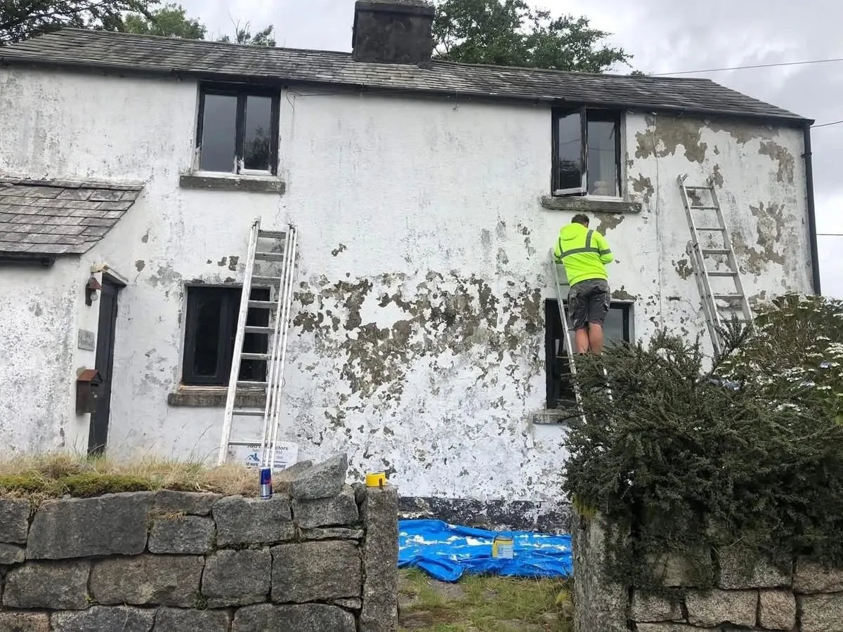 Cottage with blown, flaking render before repair in Plymouth